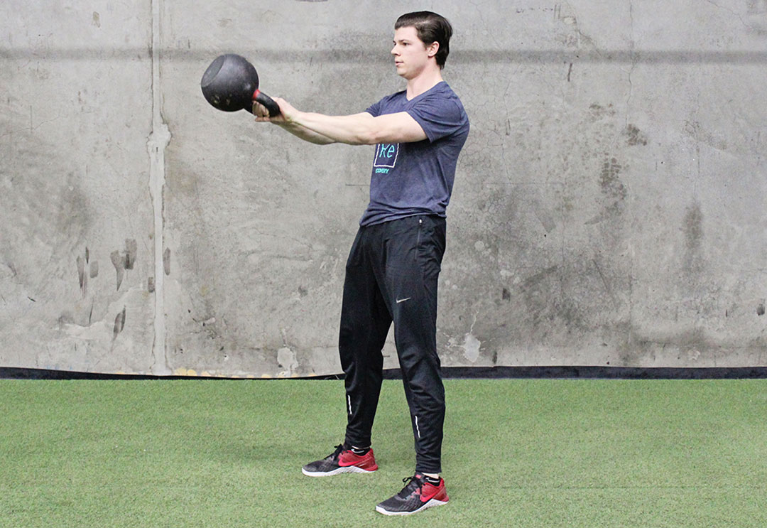 Male trainer doing a kettlebell swing