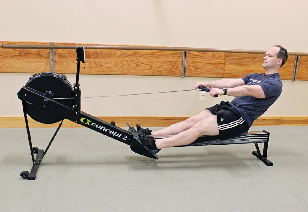Male trainer exercising on a rowing machine
