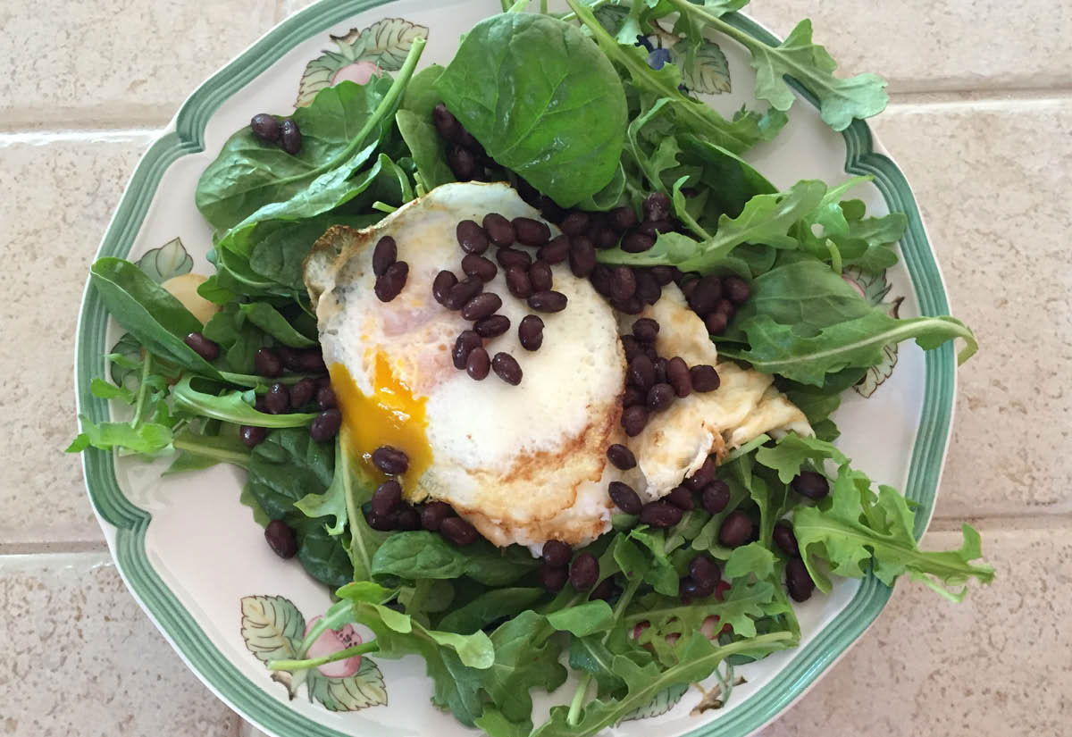 A view of a healthy rev32 meal with eggs, kale, and beans