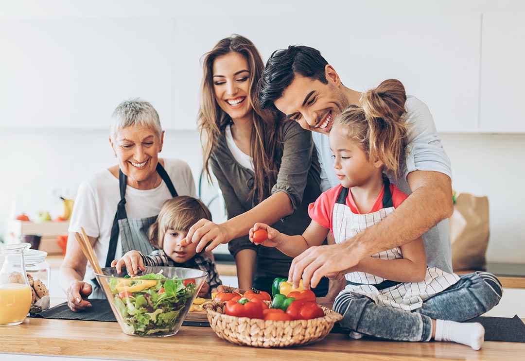 A family cooking and eating healthy foods together in the kitchen