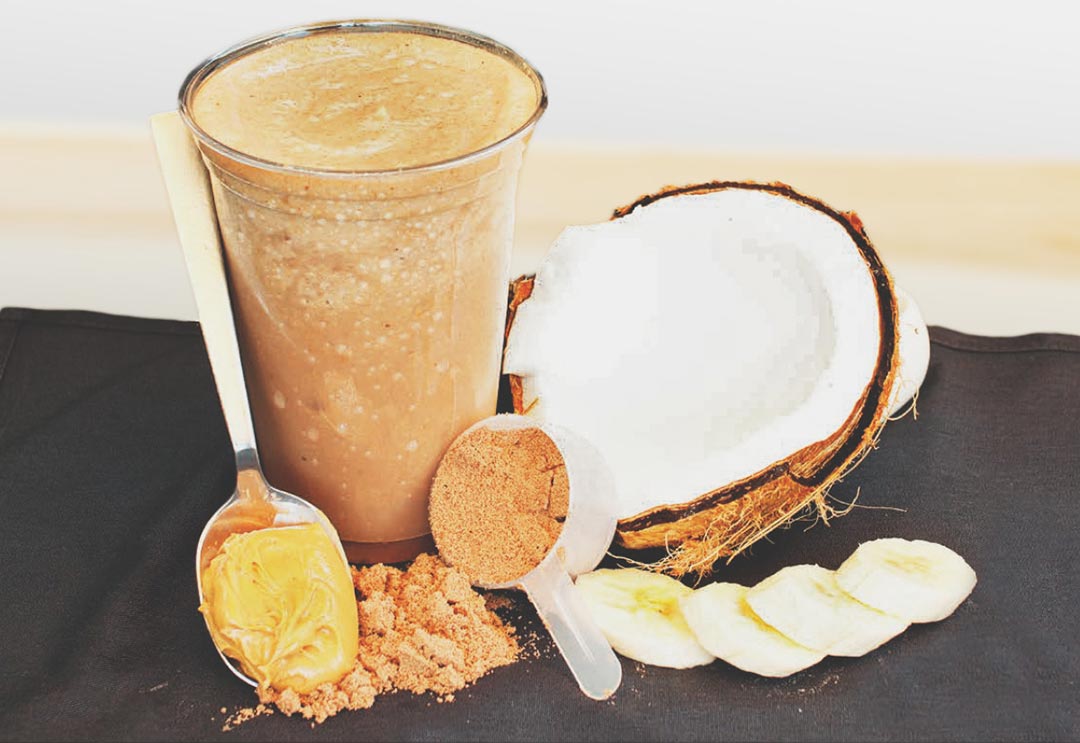 A smoothie filled with peanut butter, banana, and coconut