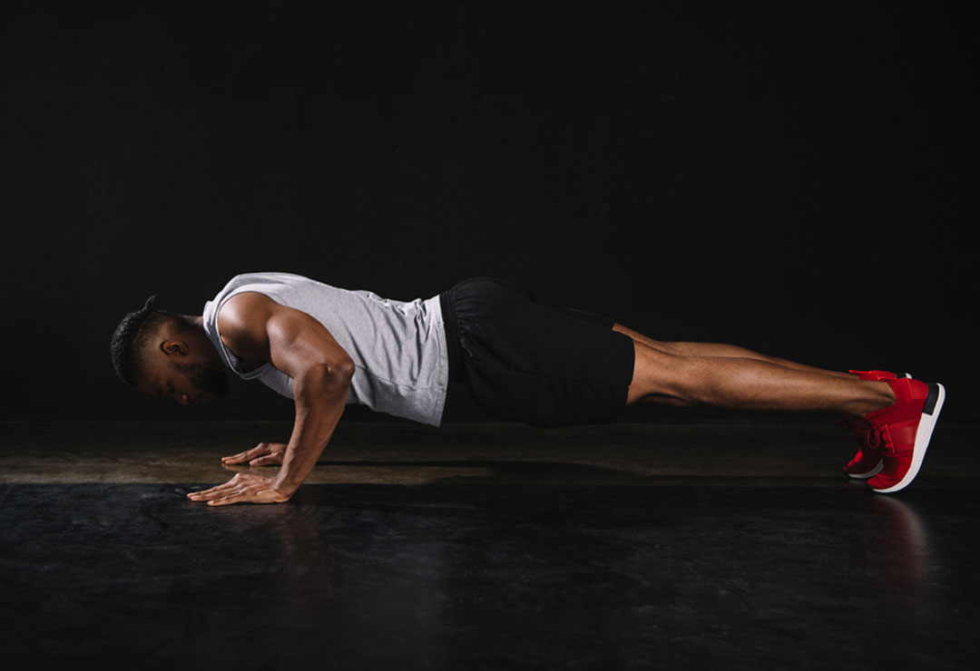 A man in a pushup learning how to progress from knee pushups to full pushups