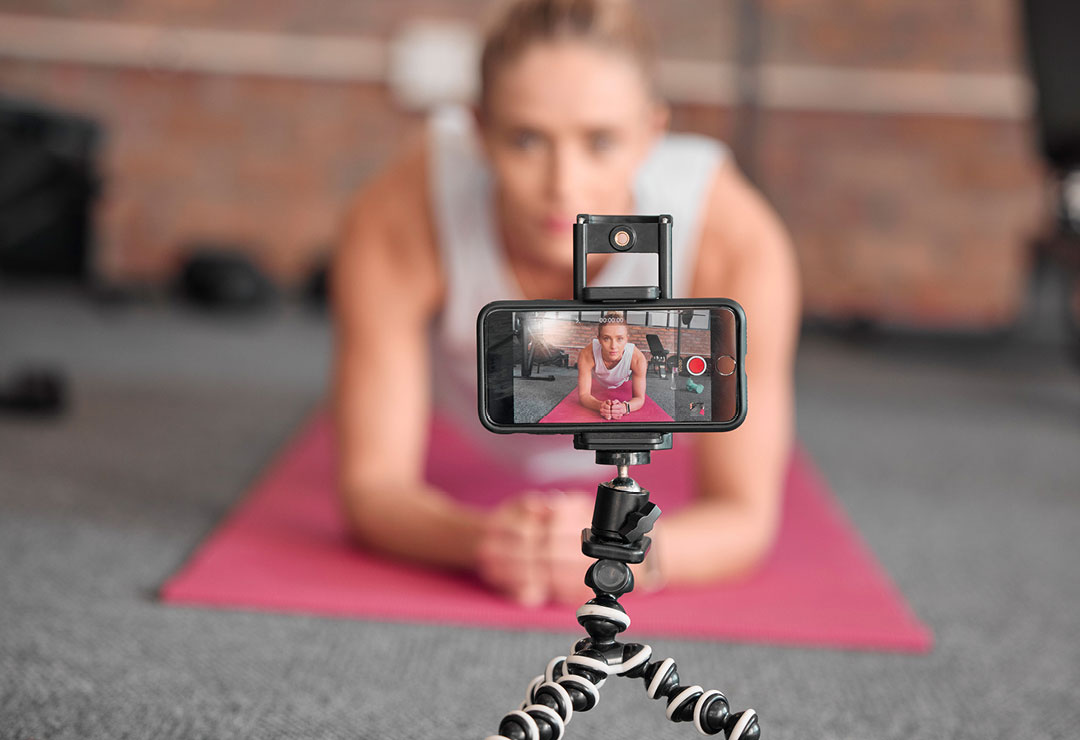 How-to-Tell-if-a-Social-Media-Fitness-Influencer-is-Legit A fitness influencer filming a fitness workout for social media