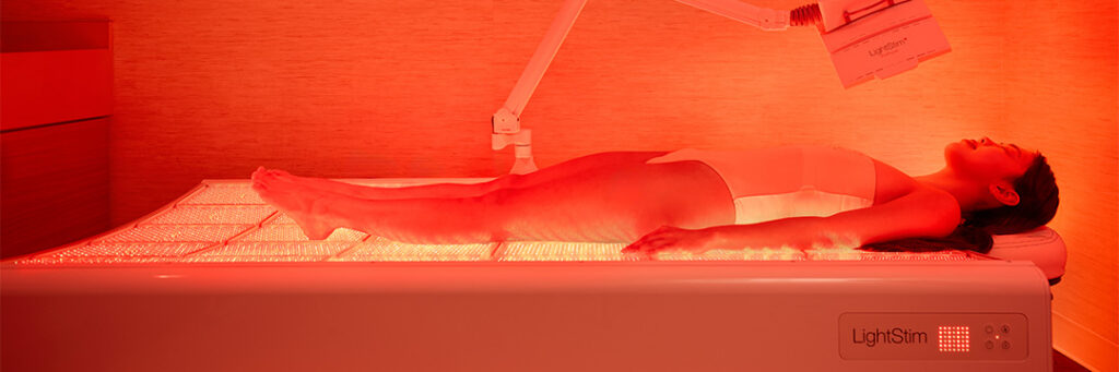 women in red light therapy full-body bed